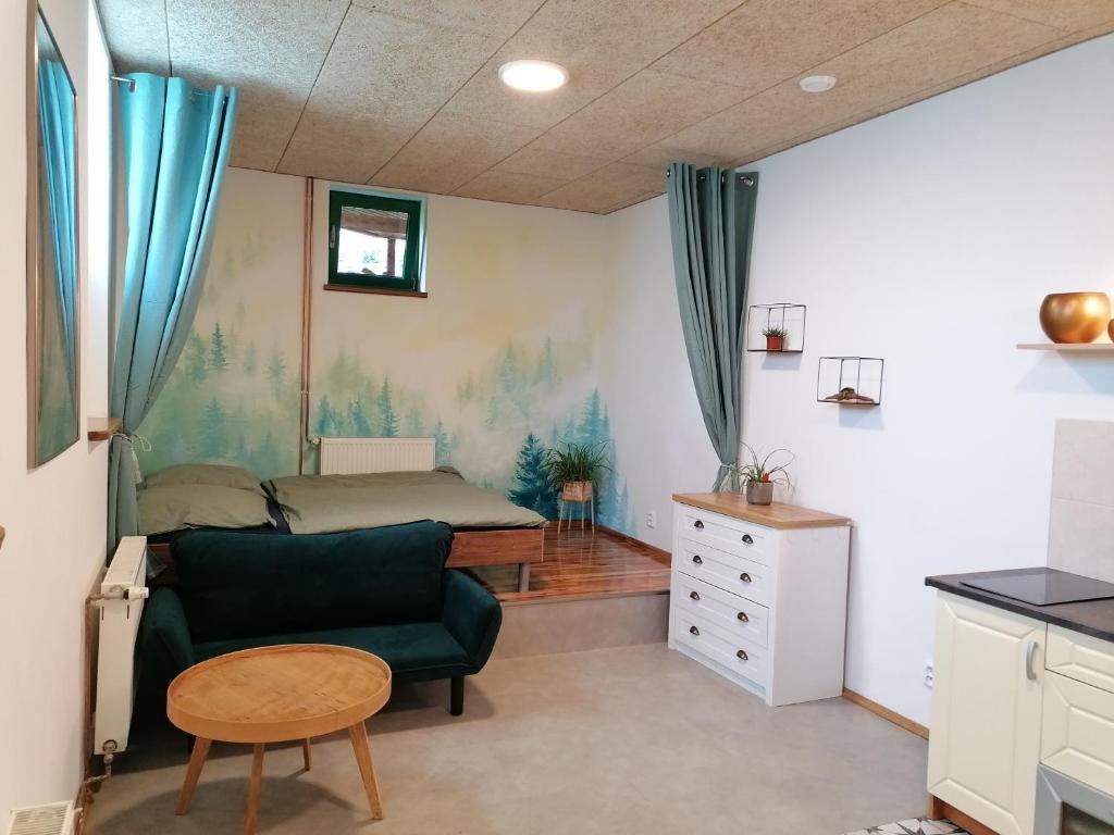 ein kleines Zimmer mit einem Sofa, einem Bett und einem Tisch in der Unterkunft Jizerský Spirit in Jablonec nad Nisou