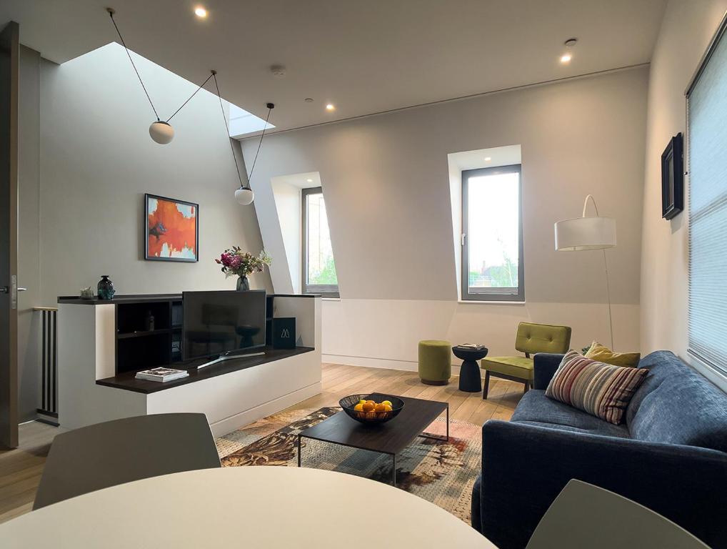 sala de estar con sofá y TV en Mirabilis Apartments - Bayham Street, en Londres