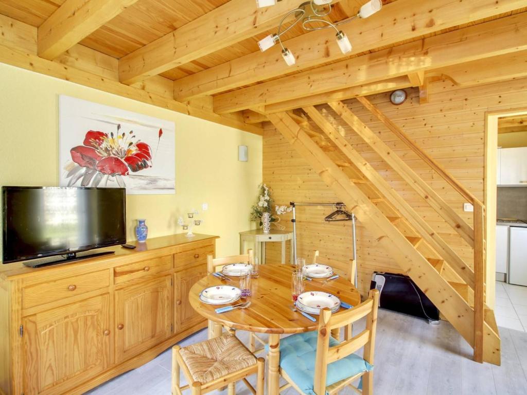 une salle à manger avec une table en bois et une télévision dans l'établissement Duplex cosy 4 pers au centre de Cauterets, proche télécabine, skis et commerces - FR-1-401-27, à Cauterets