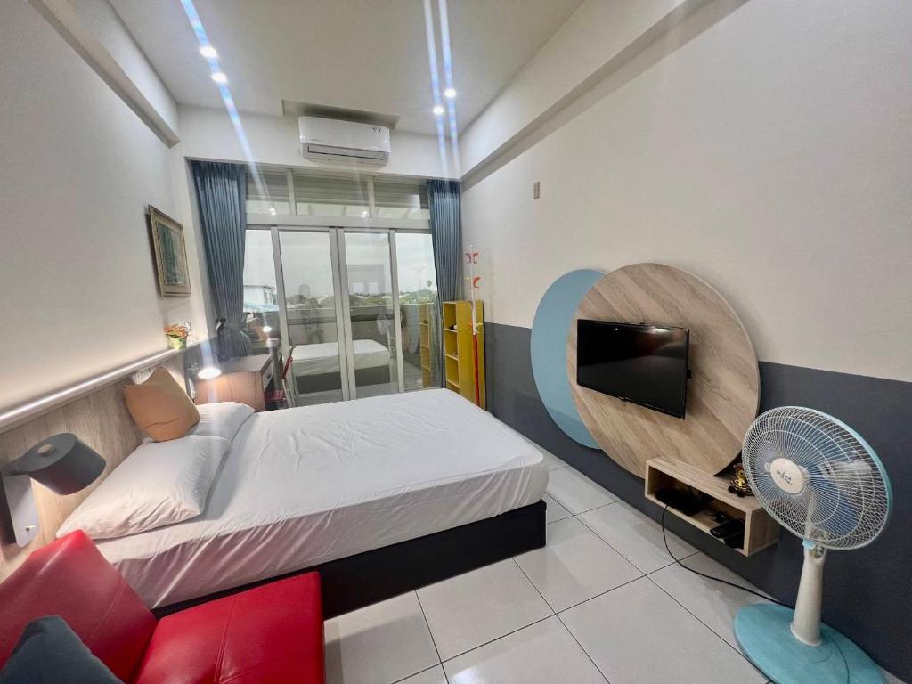 um quarto com uma cama, uma televisão e uma ventoinha em Beauty Chen's House em Tianwei