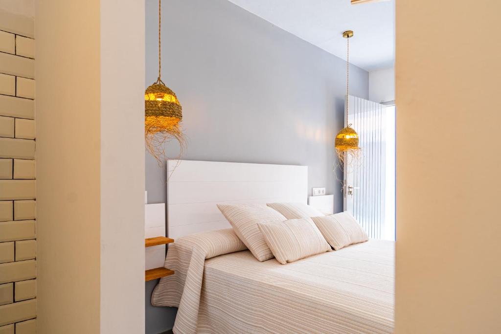 a bedroom with a white bed with two pillows at Calas De Meca in Los Caños de Meca