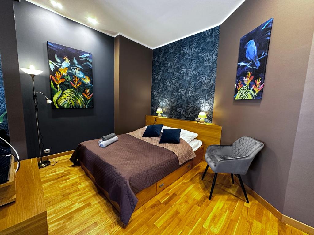 a bedroom with a bed and two paintings on the wall at DK Apartament w Centrum in Olsztyn