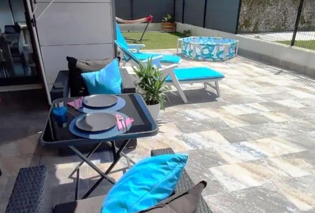 un patio con mesa y sillas. en apartamento con jardín privado a 300 metros de la playa, en Soto de la Marina