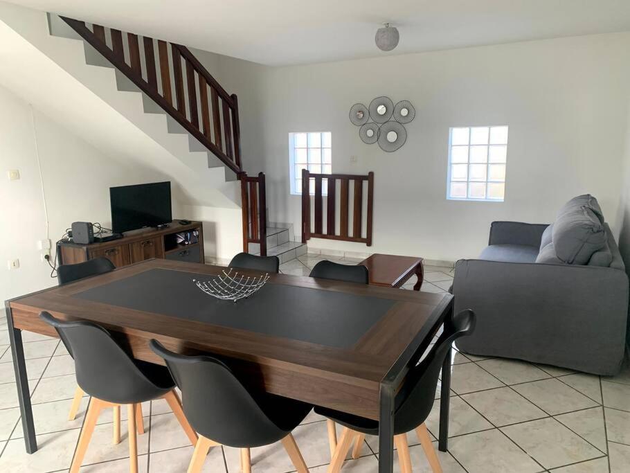 a living room with a wooden table and chairs at Villa les Poinsettias in Saint-Pierre