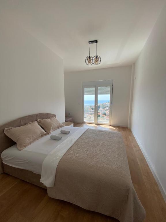 Un dormitorio blanco con una cama grande y una ventana en Apartments Radoman, en Ulcinj