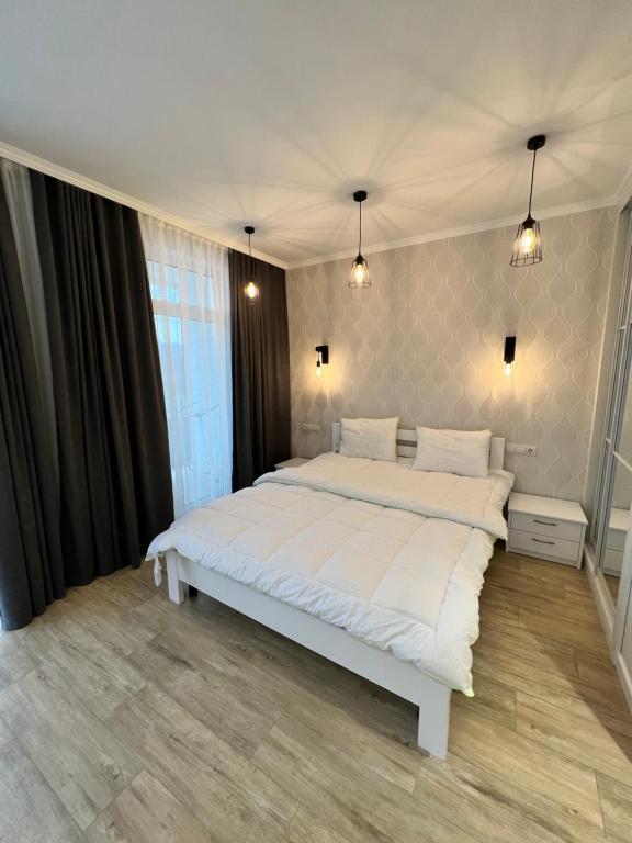 um quarto com uma grande cama branca em Sunny apartment в ЖК Сонячний Квартал em Golubinoye