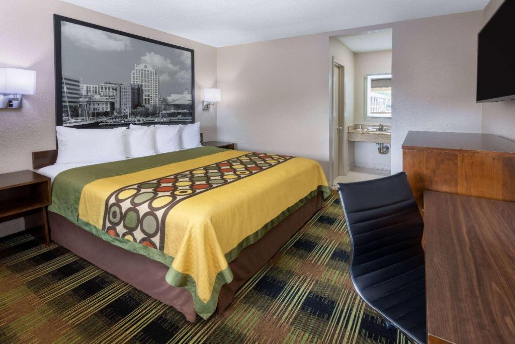 um quarto de hotel com uma cama grande e uma secretária em Super 8 by Wyndham Williamsburg/Historic Area em Williamsburg