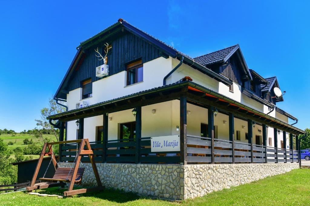 een groot wit gebouw met een zwart dak bij Vila Marija in Rastovača