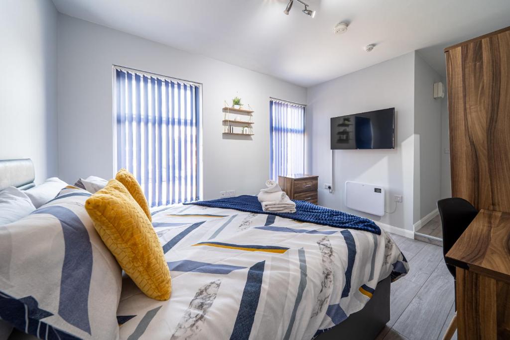1 dormitorio con 1 cama y TV en Studios with Ensuite Showers & Share Kitchens Prime Location near Hospital, Town Center Apt 3, en Saint Helens