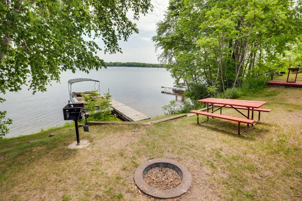a picnic table and a grill next to a lake at Pet-Friendly Wisconsin Cabin on Lake with Fire Pit! 