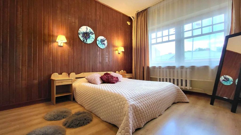 um quarto com uma cama com almofadas em Ierullē em Alūksne