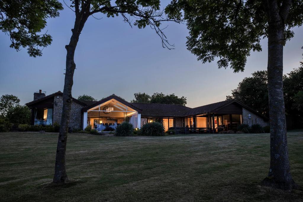 a house with a large yard with trees at Kingsley Lake View & Paddocks - A group retreat with hot tub, sports bars & spectacular lake views in the Mendip Hills AONB in Chew Stoke