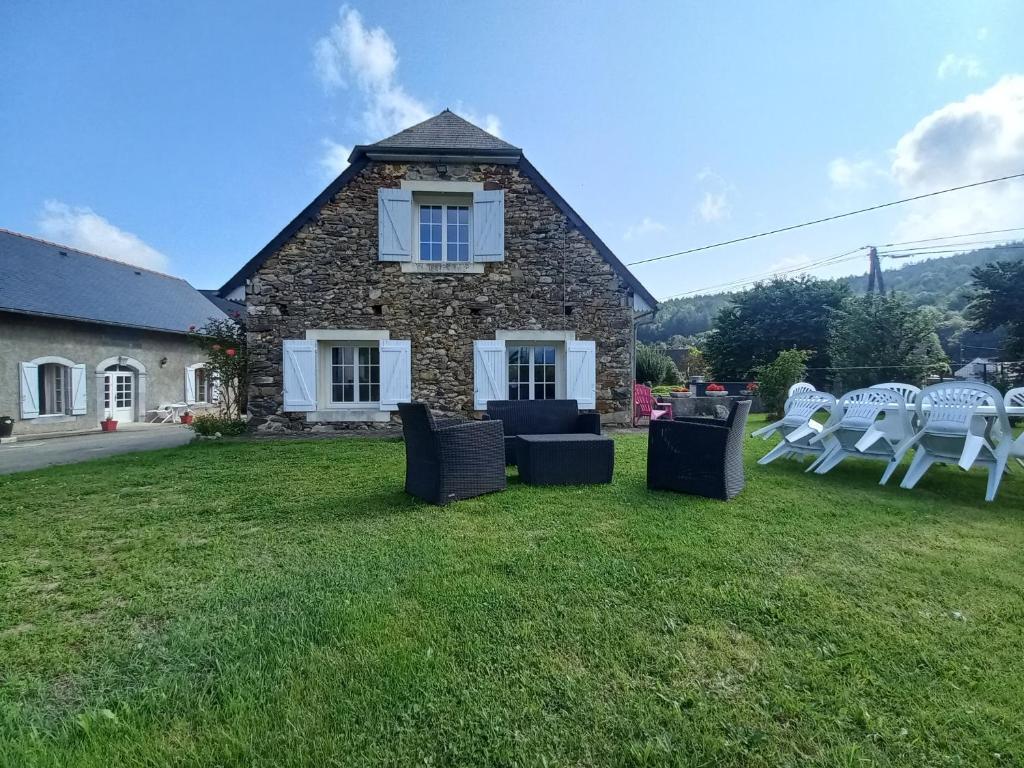 una casa de piedra con sillas y un edificio en Maison de vacances en Adé