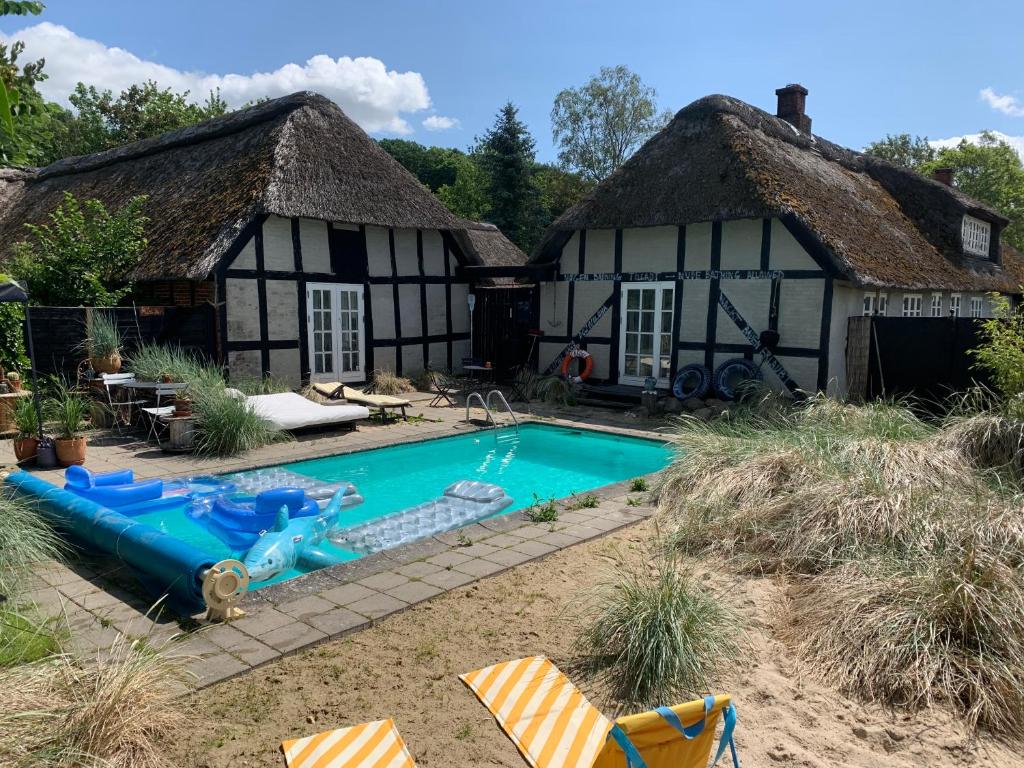 een huis met een zwembad ervoor bij Farm61 badehotellet i det midtjydske - alder +18 år in Tjele