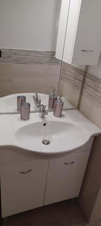 La salle de bains est pourvue d'un lavabo blanc et d'un miroir. dans l'établissement Casa Mirella, à Sanremo
