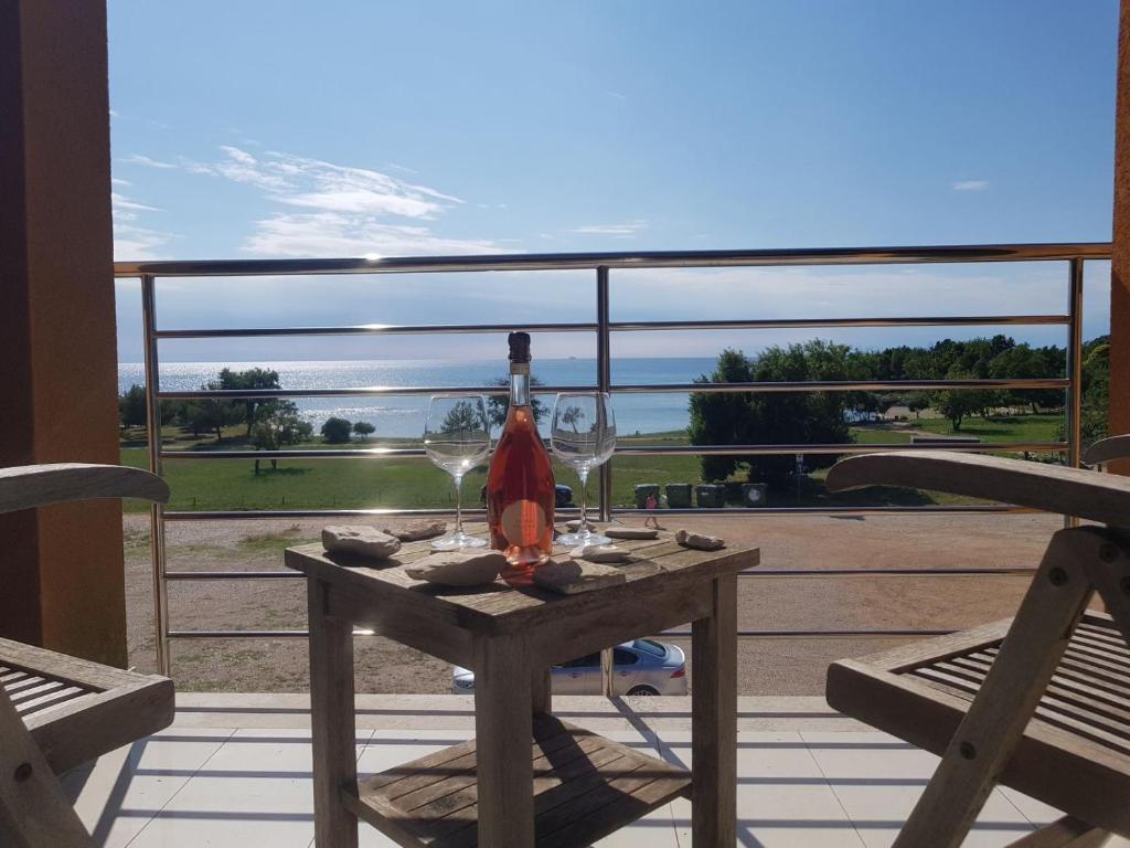 - une table avec des verres à vin sur le balcon dans l'établissement Apartments Fontana Zambratija, à Zambratija