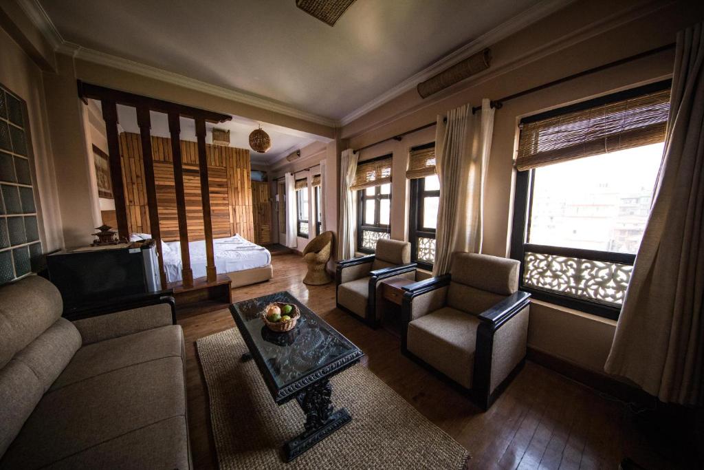 un soggiorno con divano e letto di Tajaa Pha The Heritage Home a Patan