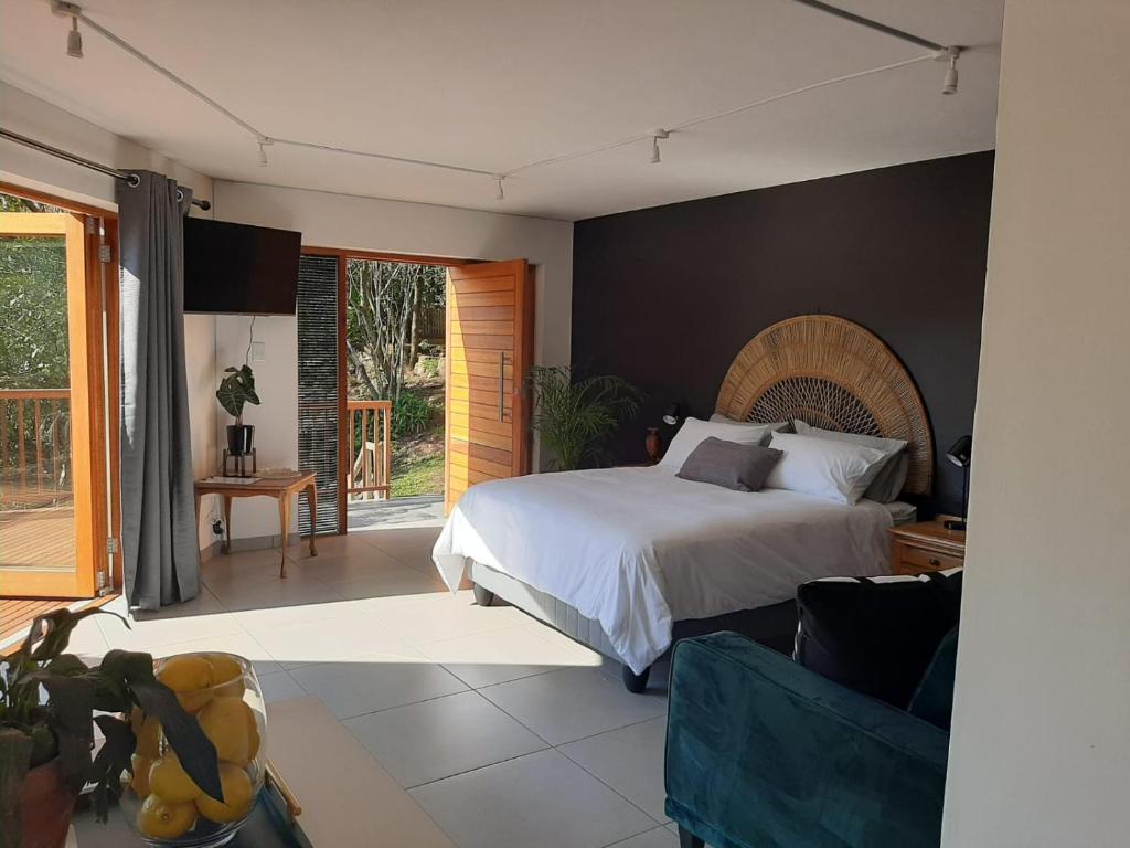 a bedroom with a bed and a living room at Nkutu River Lodge in Kloof