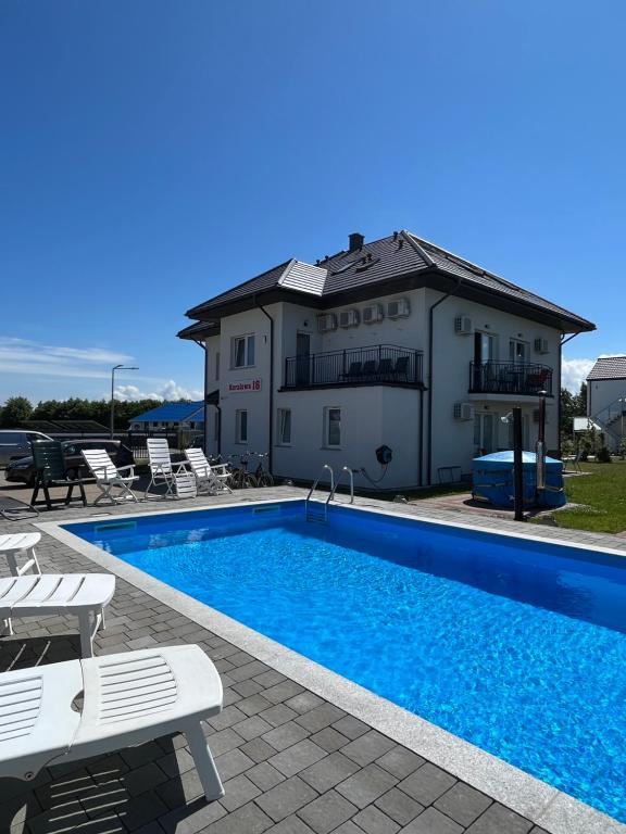 a swimming pool in front of a house at Willa Koralowa 16 - BASEN PODGRZEWANY, KLIMATYZACJA in Sarbinowo