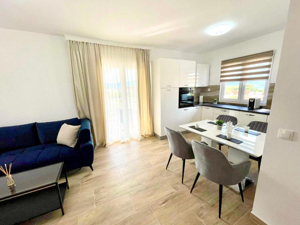 uma sala de estar com um sofá azul e uma cozinha em Villa Oliva Korcula em Korčula