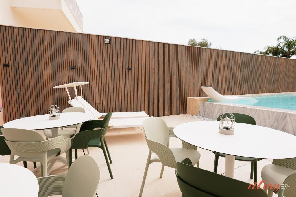 a restaurant with tables and chairs and a swimming pool at Spinola Stays in St. Julianʼs