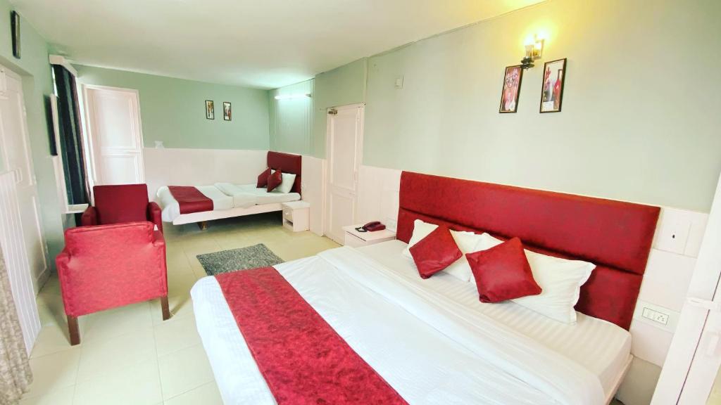 a bedroom with a large bed with red pillows at Hotel New Meadows View in Manāli