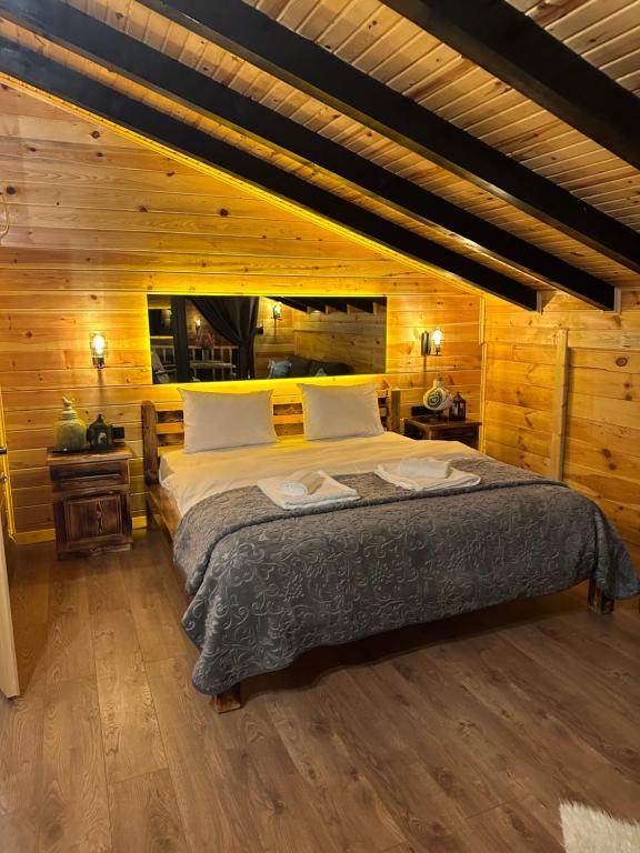 sypialnia z dużym łóżkiem w drewnianym pokoju w obiekcie Hayvore Loft w mieście Çamlıhemşin