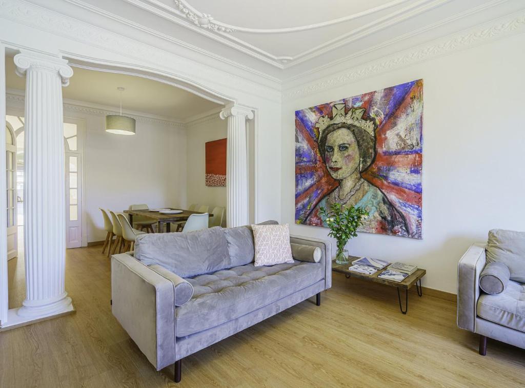 巴塞隆納的住宿－SibsBcn-PaseodeGracia Luxury Exclusive Gaudi，客厅配有沙发和墙上的绘画