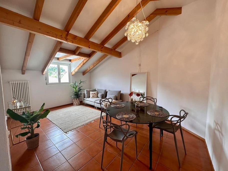 een grote woonkamer met een tafel en stoelen bij Cozy Ascona: attico mansardato in Ascona