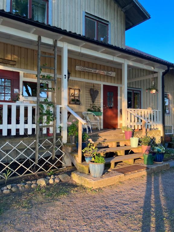a house with a wooden porch with a wooden stairs at Karaby Gård, Country Living in Kristinehamn