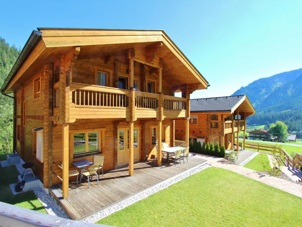 クリムルにあるModern Chalet with Jacuzzi in Krimmlの広い木造家屋(デッキ、芝生付)