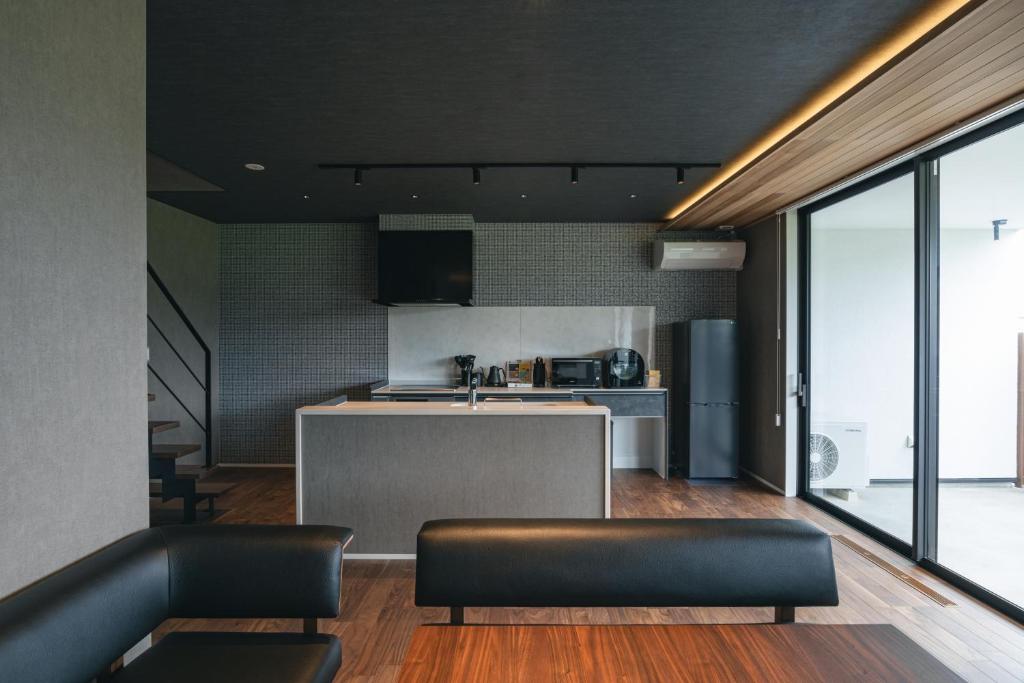 a living room with a couch and a kitchen at Fuji no Sato Alibio in Fujikawaguchiko