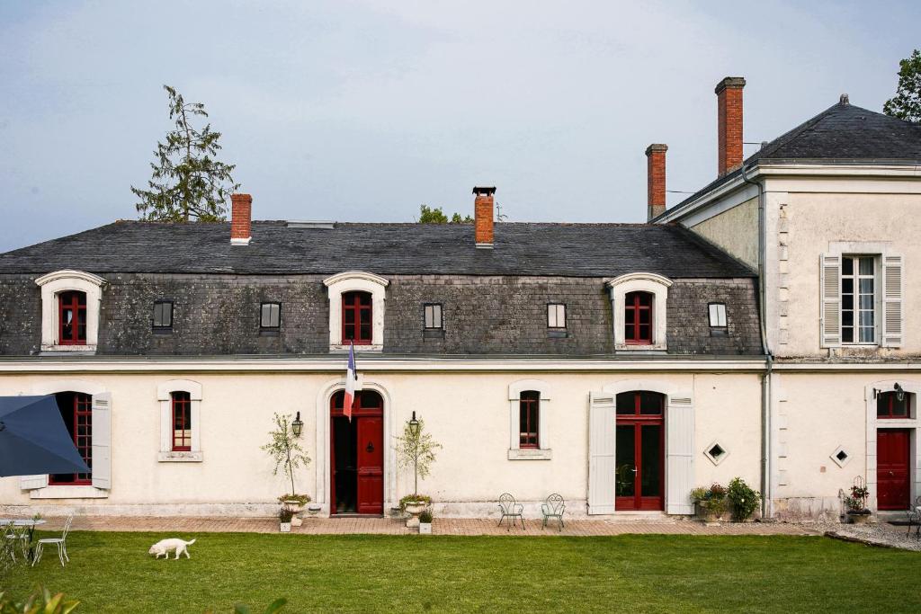 Château de Gouyas في Montagrier: بيت أبيض كبير وأبواب حمراء