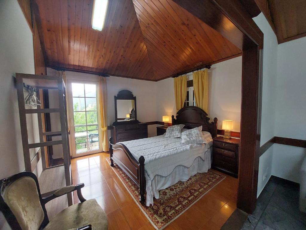 1 dormitorio con cama y techo de madera en 3A Botanical Dimensions Nature Terraces BBQ, en Faial