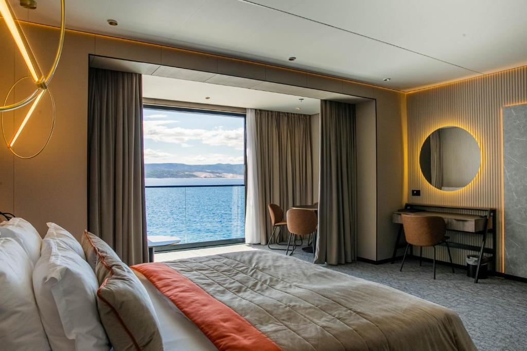 una camera d'albergo con una grande camera da letto con una grande finestra di Hotel Medistone a Omiš (Almissa)