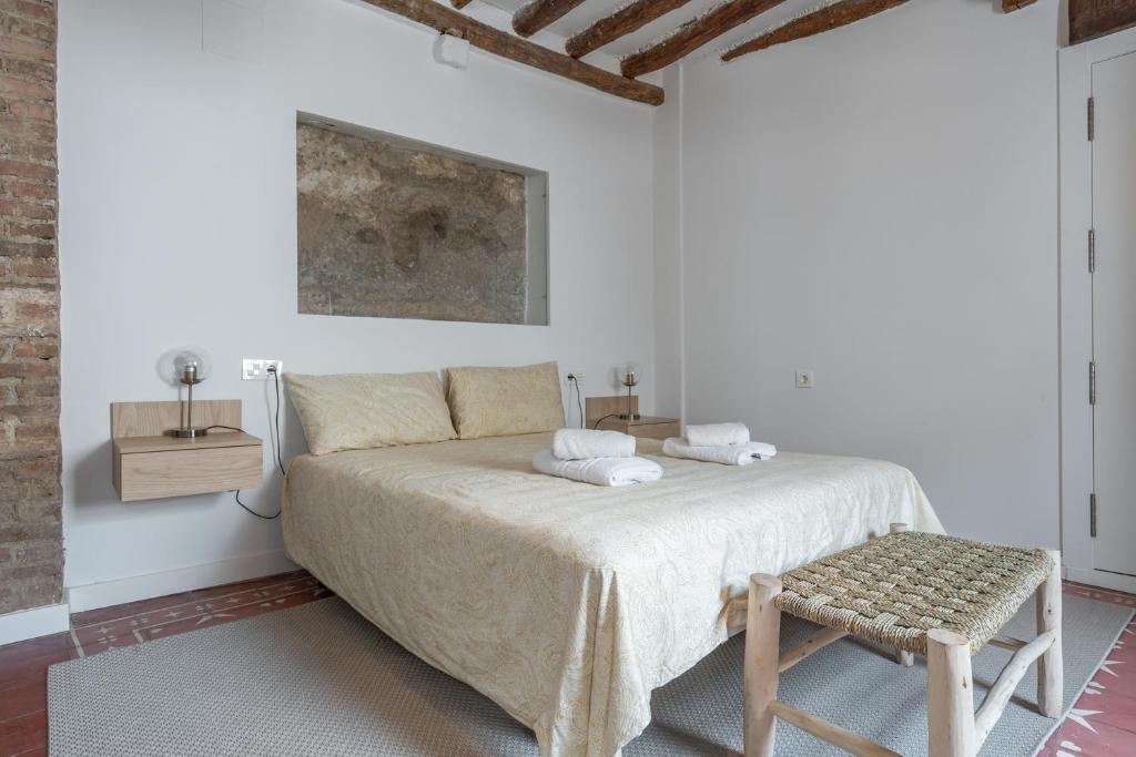Dormitorio blanco con cama y taburete en tuGuest casa del mirador, en Granada