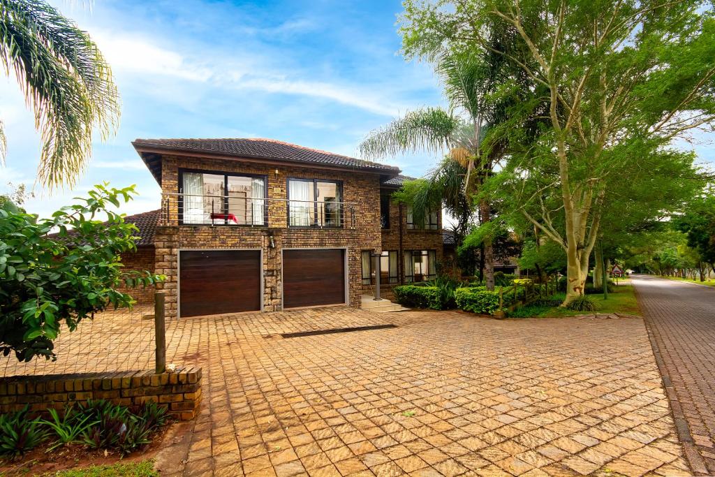 a brick house with a driveway in front of it at White River Country Estate - Self Catering - AMH Home in White River