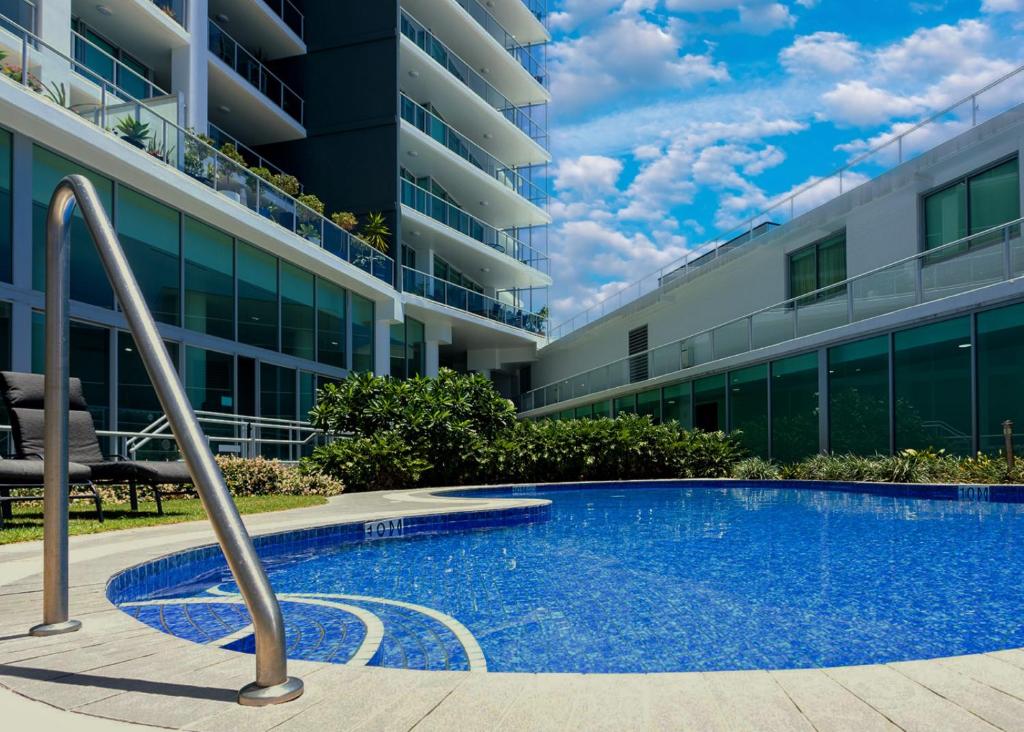 a swimming pool in front of a building at Modern 2 Bedroom Apt near Tram & Ocean in Gold Coast