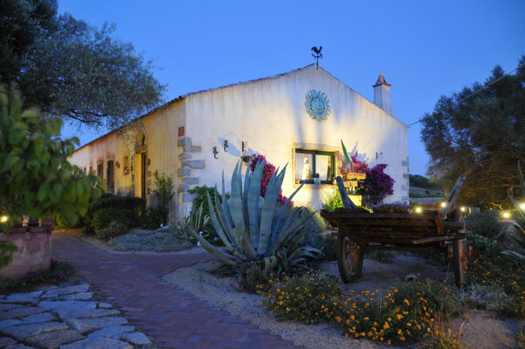 a building with a cactus and a bench in front of it at La MeSenda in Arzachena