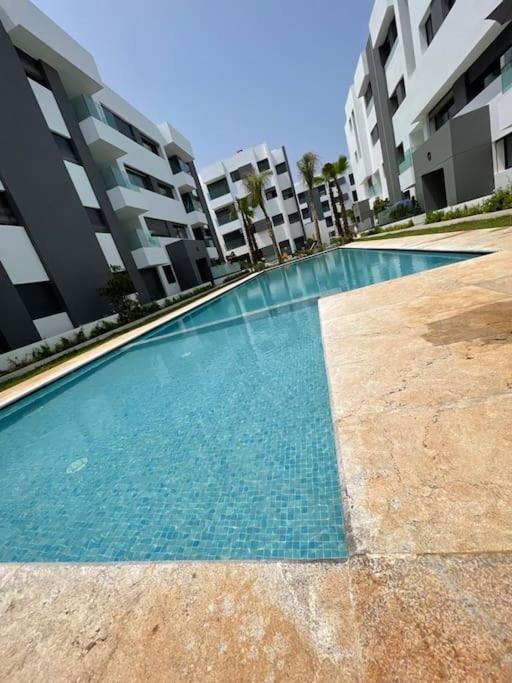 a swimming pool in front of some apartment buildings at Étoile Harhoura in El Harhoura