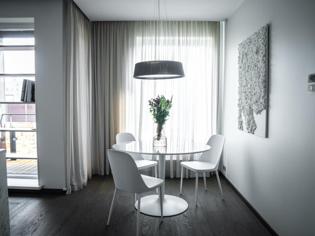 een eetkamer met een tafel en witte stoelen bij 8ERA Business Executive Rotermanni Apartments in Tallinn