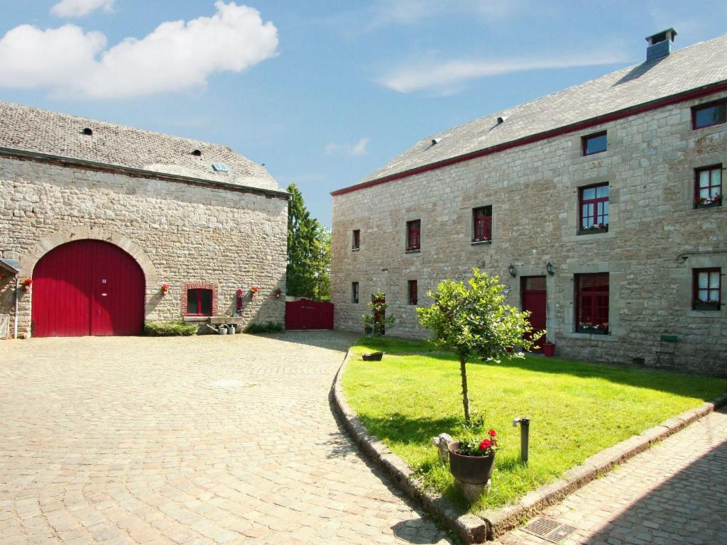 um grande edifício de tijolos com uma garagem vermelha em Luxury Holiday Home in Melreux Hotton with Sauna em Melreux