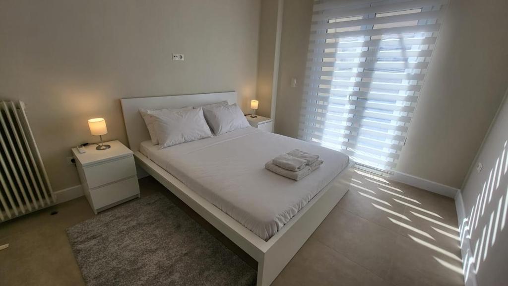 a white bed in a room with a window at Elegant Apartment For 4 Ppl In P. Faliro in Athens