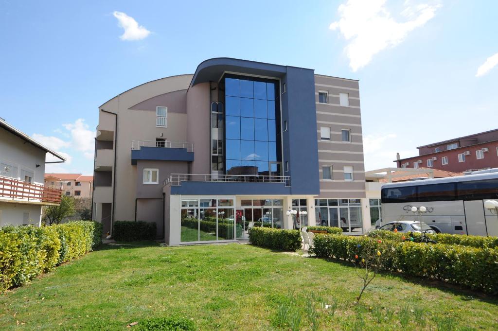 ein großes Gebäude mit einem Hof davor in der Unterkunft Hotel Rosabel in Međugorje