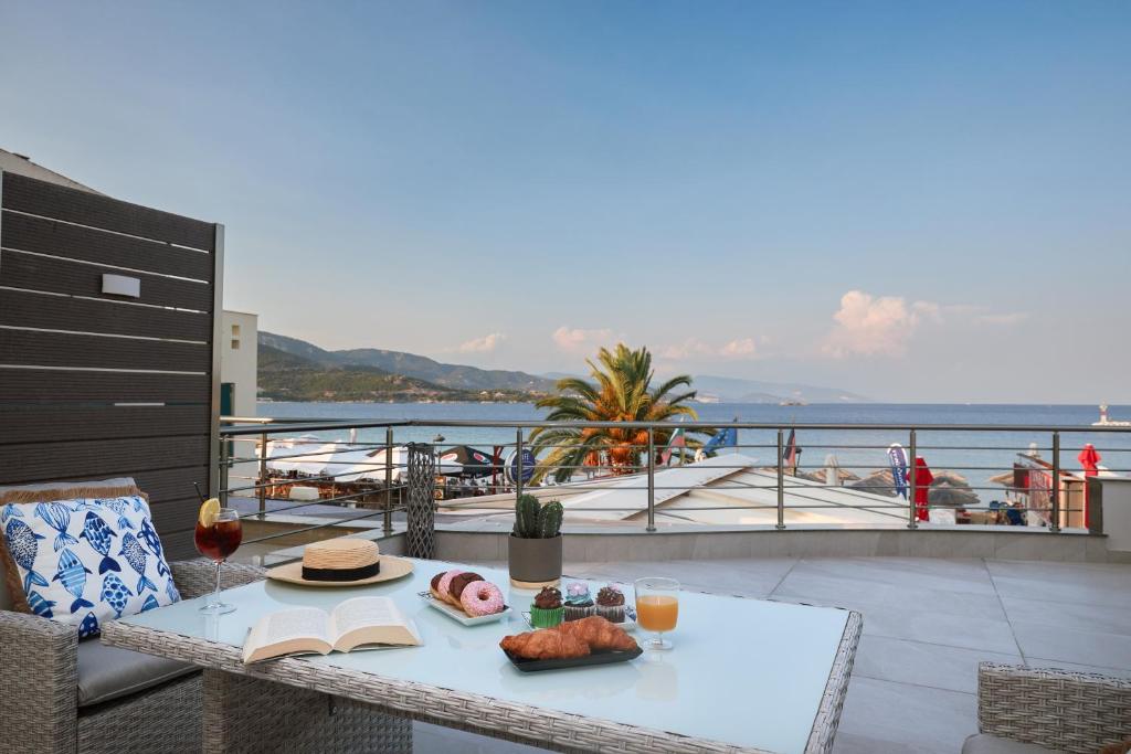 a table with a plate of food on a balcony at Horizon Seaside Living in Iraklitsa