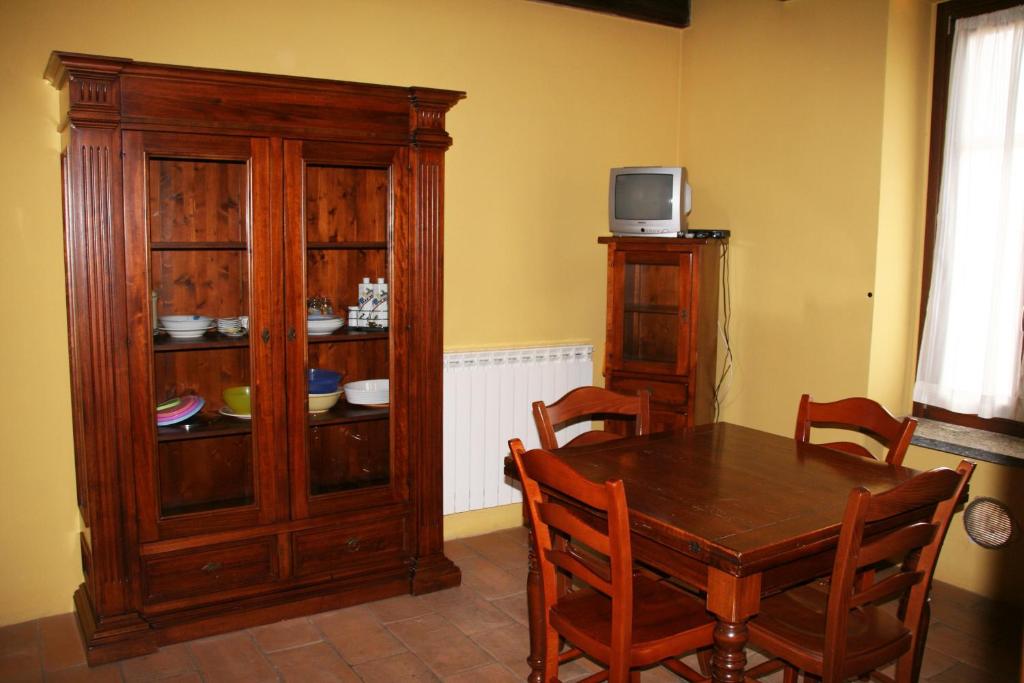 uma sala de jantar com uma mesa e um armário de madeira em Agriturismo Cascina la Palazzina em Albairate