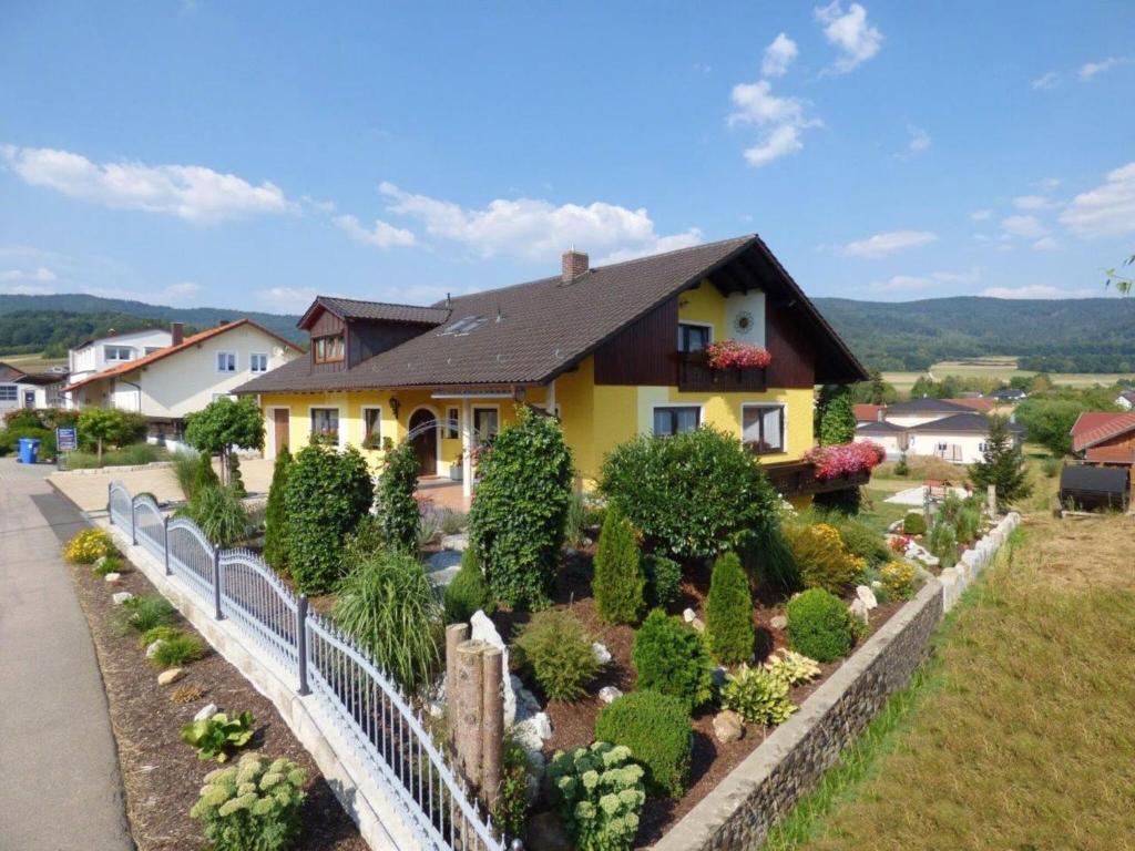 a house with a garden in front of it at Scenic Apartment with Balcony Garden Deckchairs Barbecue in Gleißenberg