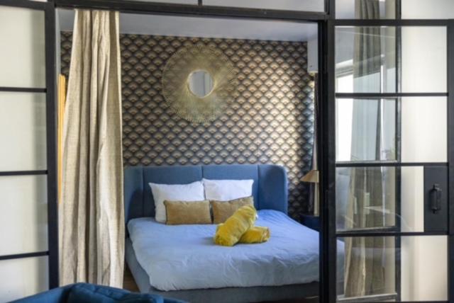 a bedroom with a blue bed with a yellow teddy bear on it at MYAPPARTBORDEAUX in Bordeaux