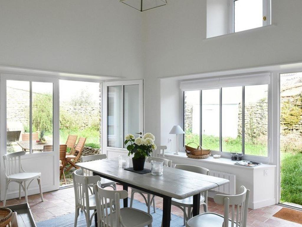 une salle à manger avec une table et des chaises dans l'établissement Maison au Charme du Village avec Jardin et Wi-Fi - 2 Chambres, 2 Salles d'eau, Cheminée - FR-1-434-11, aux Portes