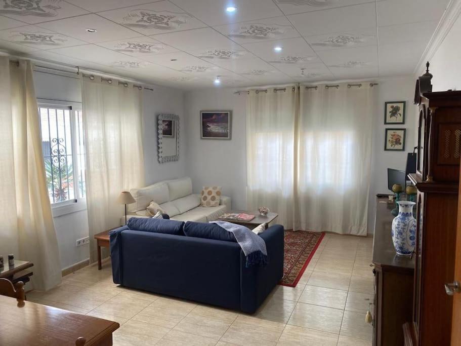 uma sala de estar com um sofá azul e uma mesa em Big & cozy beach canet de Mar em Canet de Mar